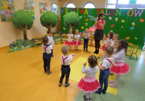 Dzieci tańczą w kole, poruszają paluszkami u rączek.
